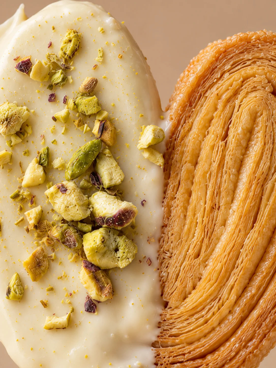 Detalle de palmera sin gluten de chocolate blanco y pistacho con capas finas de hojaldre artesanal.
